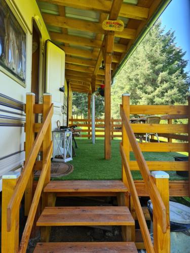 a wooden porch with a bench and a table at Guesthouse Wallenborn - Caravan Chalet in Wallenborn