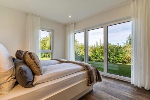 ein Schlafzimmer mit einem großen Fenster und einem Sofa in der Unterkunft Tischneck Chalets in Hardt