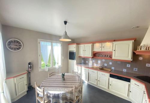 a kitchen with a table and a dining room at Gite du Plessis in Saint-Onen-la-Chapelle