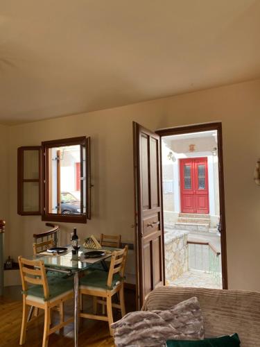 a dining room with a table and a red door at Delfi's cozy maisonette in Delfoi