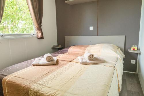 a bedroom with a bed with towels on it at Bontempo Village La Yole in Saint-Jean-de-Monts