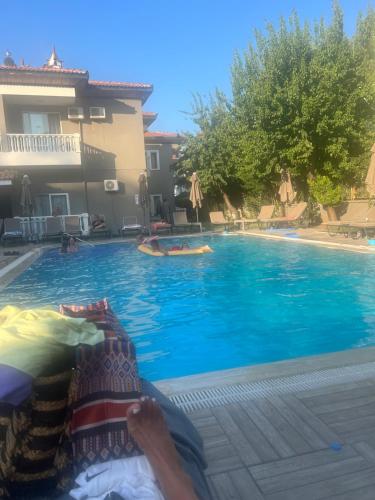 a person laying on a bed next to a swimming pool at Imperial Apart in İçmeler