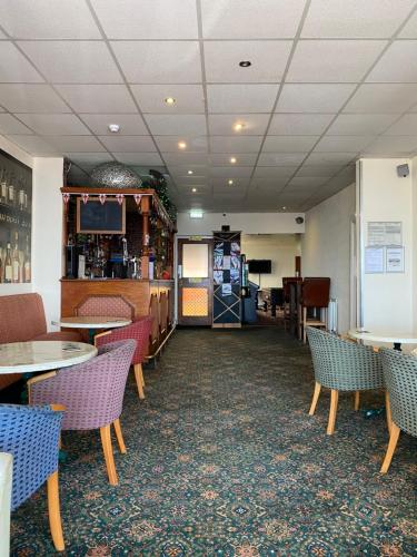 een eetkamer met tafels en stoelen en een bar bij South Beach Hotel in Blackpool