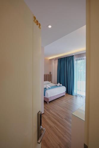 a bedroom with a bed and a room with a window at HOTEL DENOEL in Ksamil