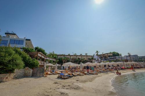 a beach with a bunch of chairs and umbrellas at HOTEL DENOEL in Ksamil