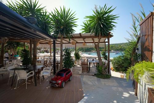 a small red car parked under a pavilion on a patio at HOTEL DENOEL in Ksamil
