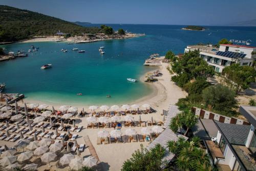 an aerial view of a beach with chairs and umbrellas at HOTEL DENOEL in Ksamil
