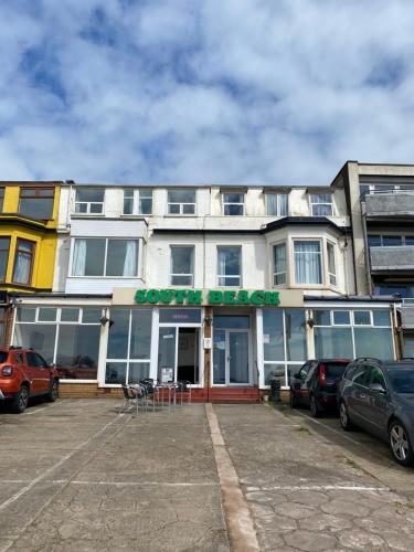 a building with cars parked in a parking lot at South Beach Hotel in Blackpool