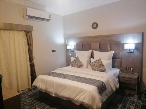 a hotel room with a large bed with two pillows at فندق اجنحة السمو بجازان in Jazan