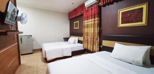 Cette chambre comprend 2 lits et une télévision. dans l'établissement Grand S'kuntum Hotel Syariah, à Metro