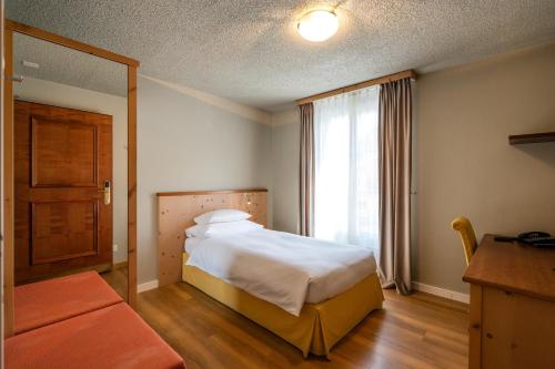 a hotel room with a bed and a window at Seehof Reduit in Davos