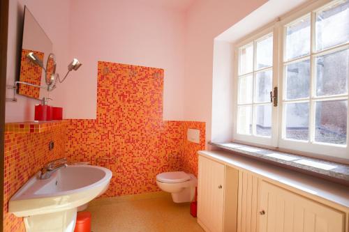 Un baño con lavabo, inodoro y ventana. en Monferrato, Intera casa uso esclusivo giardino recintato posto auto privato, ideale per famiglie con animali, en Lu