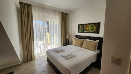 A bed or beds in a room at KHARMA BEACH CLUB SPA APOLLONIUM BAY VILLAS