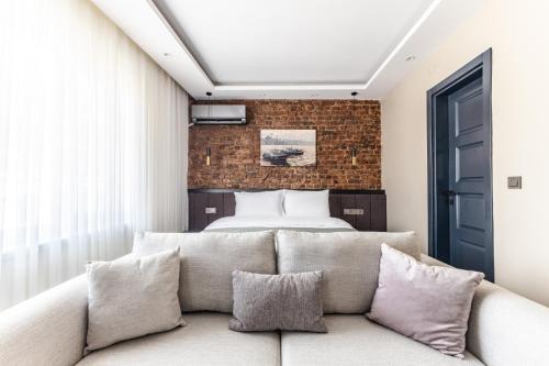 ein Schlafzimmer mit einem Bett und einem Sofa mit Kissen in der Unterkunft Sea View Studio Flat Near Beylerbeyi Palace in Istanbul