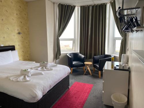 a hotel room with a bed and two chairs at South Beach Hotel in Blackpool