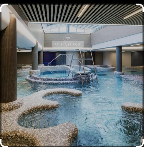 une grande piscine d'eau dans un bâtiment dans l'établissement STUDIO 3 Mn de la PLAGE Terrasse Vélos Proche de la ville fortifiée, à Saint-Malo