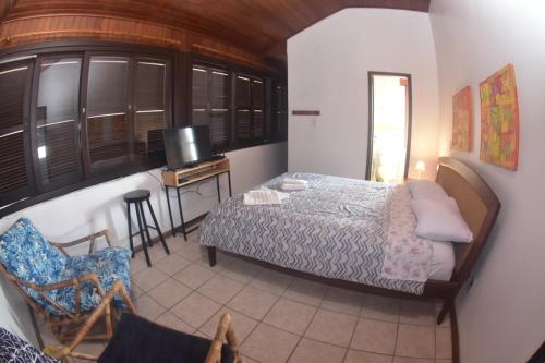 sypialnia z łóżkiem, biurkiem i telewizorem w obiekcie Pousada Quintal ! w mieście Xangri-lá