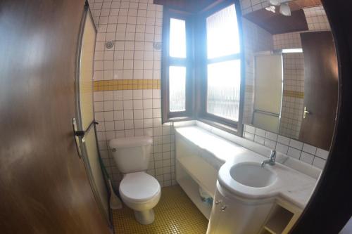 łazienka z toaletą, umywalką i oknem w obiekcie Pousada Quintal ! w mieście Xangri-lá