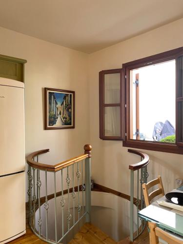 a kitchen with a spiral staircase and a window at Delfi's cozy maisonette in Delfoi