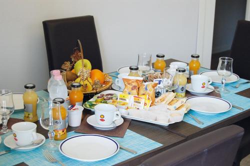 una mesa con platos y comida encima en B&B dei Gemelli, en Bareggio