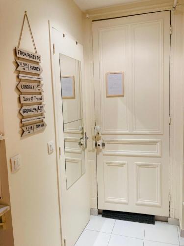 a hallway with a white door and signs on the wall at STUDIO PARIS Gare de Lyon in Paris