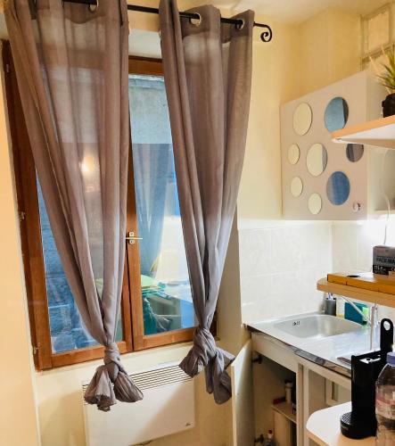 - une cuisine avec une fenêtre et un évier dans l'établissement STUDIO PARIS Gare de Lyon, à Paris