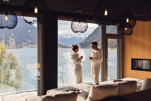 a man and woman standing in front of a window at Seehotel Einwaller - adults only in Pertisau