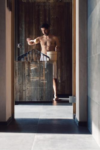 a man standing in a doorway with a bath tub at Seehotel Einwaller - adults only in Pertisau