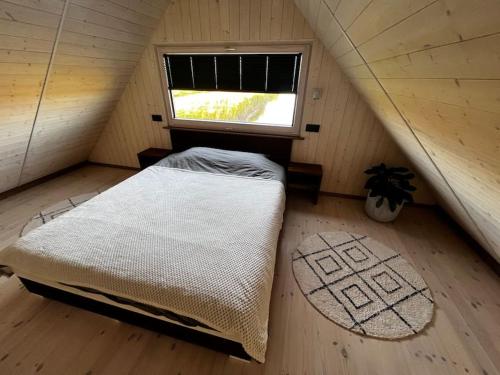 ein Schlafzimmer mit einem Bett im Dachgeschoss mit einem Fenster in der Unterkunft Feel the breeze - cozy luxury in Elva