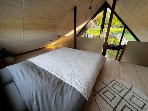 Bett in einem kleinen Zimmer mit einem großen Fenster in der Unterkunft Feel the breeze - cozy luxury in Elva