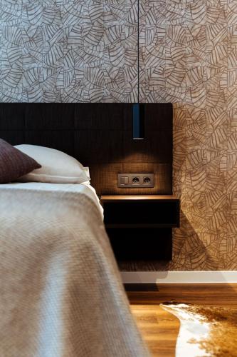 a bedroom with a bed and a wall with a pattern at Cosmopolite Hotel Nieuwpoort-Bad in Nieuwpoort