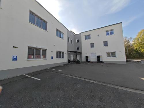 an empty parking lot next to a white building at Apartment E2 - Gut ausgestattete 3-Zimmerwohnung 64 qm, für 1-3 Personen 1 DZ 1EZ in Gravenwerth