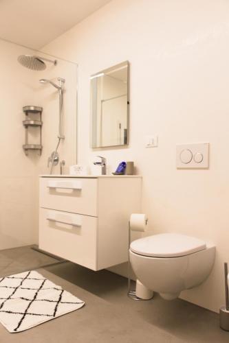 a white bathroom with a toilet and a sink at Dimora Relax in Costigliole dʼAsti