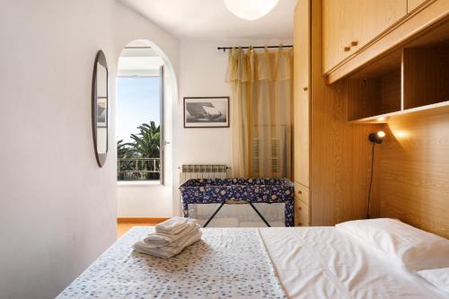 a bedroom with a bed and a chair and a window at Appartamento Celsi in Moneglia