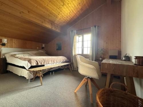 a bedroom with a bed and a desk and a chair at Chalet Rose Bay in Leysin