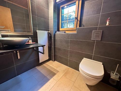 a bathroom with a white toilet and a sink at Chalet Rose Bay in Leysin