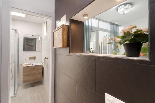 une salle de bain avec un lavabo, un miroir et une fenêtre dans l'établissement Bungalow Sonemar Paradise, à Maspalomas