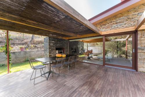 a patio with a table and chairs on a deck at Casa de Medas - Private country house with outdoor spa and river view only 25 minutes away from Oporto in Medas