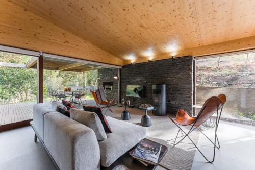 a living room with a couch and a fireplace at Casa de Medas - Private country house with outdoor spa and river view only 25 minutes away from Oporto in Medas