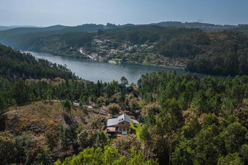 a house on a hill next to a river at Casa de Medas - Private country house with outdoor spa and river view only 25 minutes away from Oporto in Medas