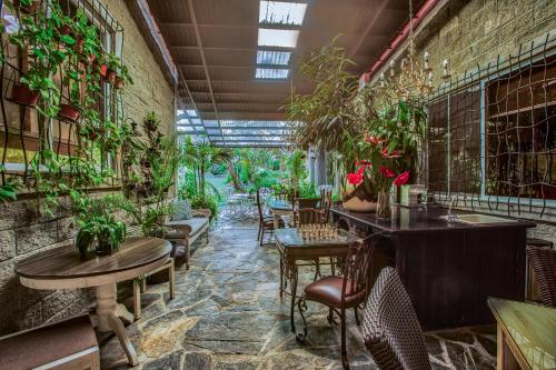a restaurant with tables and chairs and plants on the walls at Casa Madre Tierra in Valle de Anton