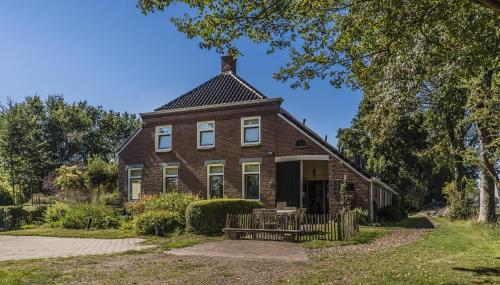 an old brick house with a chimney on top at Appartementen BuitenWedde Westerwolde in Wedde