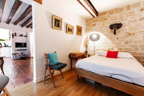 une chambre avec un lit et un mur en pierre dans l'établissement Veeve - Rustic Allure, à Paris