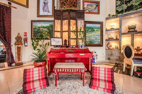 a living room with a red piano and two chairs at Casa Madre Tierra in Valle de Anton