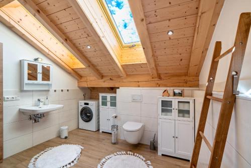 bagno con lavandino, servizi igienici e finestra. di Wohnung Brauneck a Gaißach