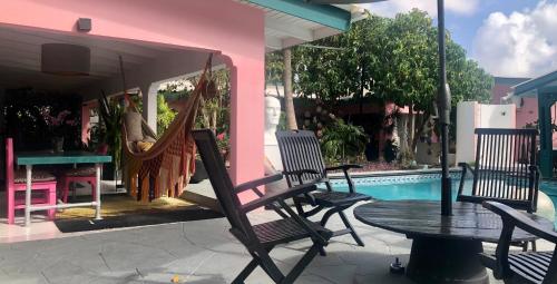 a patio with a table and chairs next to a pool at THUISHAVEN boutique mini-resort - fantastic garden and large pool - adults only in Willemstad