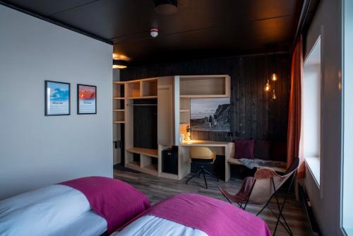 um quarto com uma cama, uma secretária e uma mesa em Melbu Hotell em Melbu