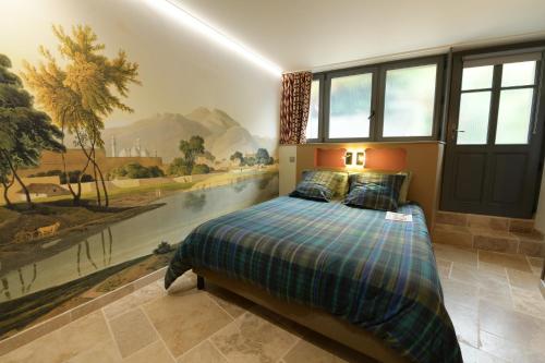 1 dormitorio con 1 cama con una pintura en la pared en exceptionnelle maison de charme à 50m du port et de sa plage en Cancale