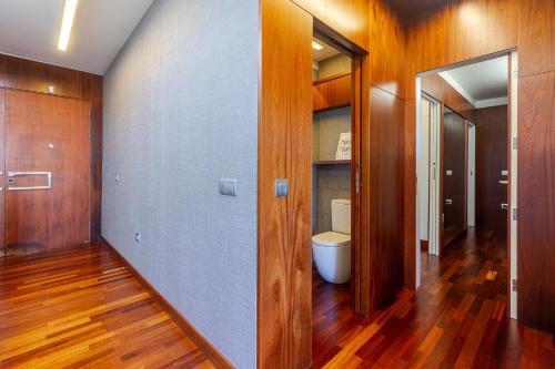 a bathroom with a toilet in a room with wooden floors at Villa Al Alba in Tafira Baja