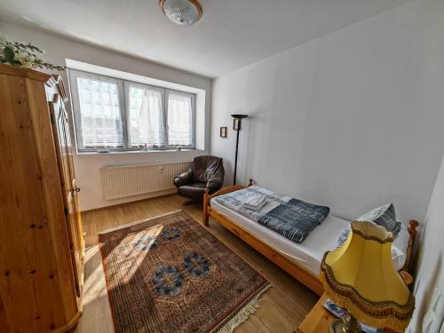 - une chambre avec un lit, une chaise et une fenêtre dans l'établissement Apartment O3 - Gehobene 6-Zimmer Wohnung 175qm für 1-7 Personen 2x DZ 3x EZ, à Grafenwöhr